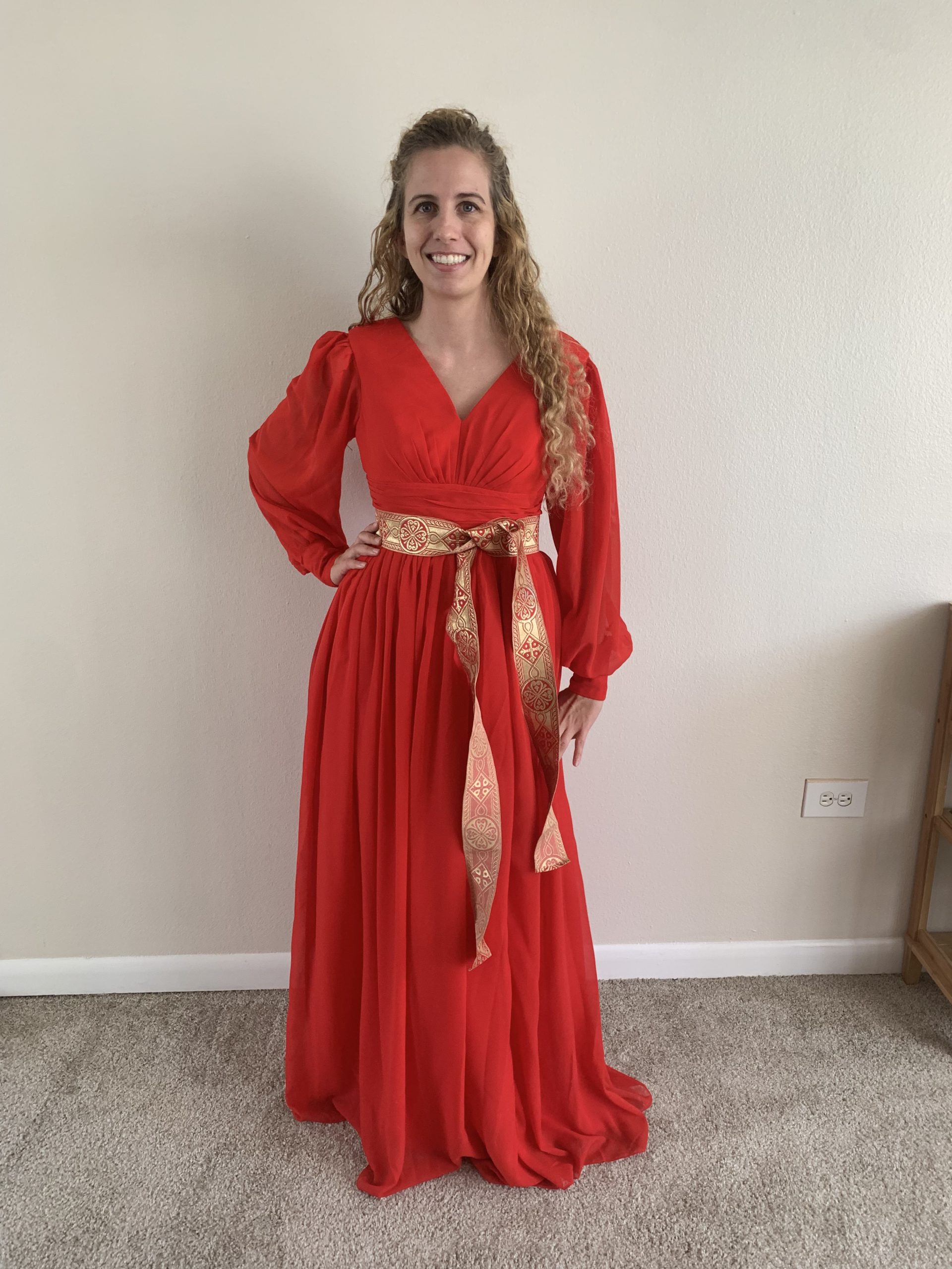 Long red dress with long sleeves and gold sash